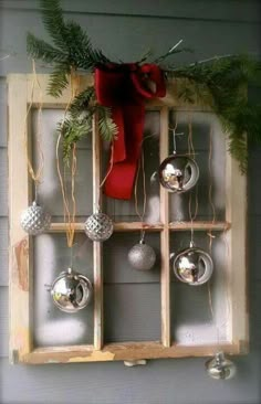 an old window is decorated with christmas ornaments