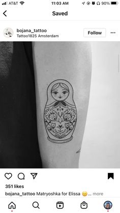 a small tattoo on the arm of a woman with an image of a russian doll