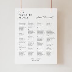 a wedding seating chart hanging on a string with the words our favorite people written below it