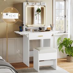 a white vanity table with a mirror and stool next to a plant in a bedroom