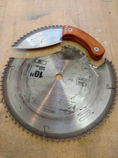 a pair of knives sitting on top of a metal bladed circular sawtoother