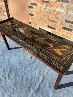 a table that has been decorated with pictures on it and is sitting in front of a brick wall