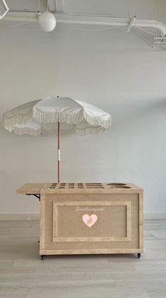 an umbrella is placed on top of a bed in the middle of a room with white walls