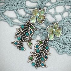 "Charming and romantic with a touch of vintage. This pretty pair of leaf vine earrings is made of a serene palette of matte gray and antique silver seed beads, stitched with splashes of teal and green crystals. The flower ear post is brass hand painted with verdigris patina for a vintage look. Earring measurements: height: approx. 2 ½\" inches from the top of the ear post to the bottom. Width is approx. 1\". Please check out more earring designs: https://www.etsy.com/shop/KareninaJewelryArt?ref=seller-platform-mcnav§ion_id=23574096" Elegant Turquoise Chandelier Earrings With Round Beads, Elegant Turquoise Chandelier Earrings, Elegant Turquoise Flower Earrings Nickel Free, Elegant Turquoise Nickel-free Flower Earrings, Elegant Bead Caps Drop Earrings Jewelry, Bohemian Beaded Earrings With Flower Charm, Elegant Drop Earrings Jewelry With Bead Caps, Elegant Drop Earrings With Bead Caps, Delicate Green Flower Earrings For Pierced Ears