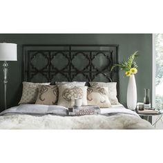 a bedroom with green walls and white bedding has a large metal headboard on it's side