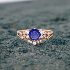 a close up of a ring with a blue stone in the middle and diamonds around it