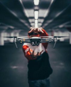 a person holding a small black and white remote control helicopter in their hands, with the camera pointed at it