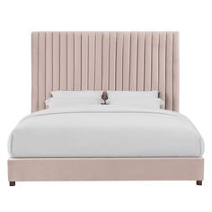 a large bed with a beige headboard and pillows on top of it's sides