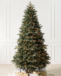 a small christmas tree sitting on top of a wooden floor next to a white wall