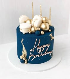 a blue birthday cake with gold decorations on it