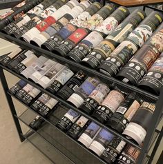 there are many different types of coffee cups on the shelf in this store, and one is full of them