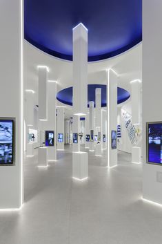 an art gallery with white walls and blue ceilinging is lit by recessed lights