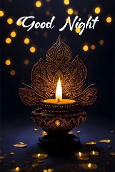 a lit diya with the words good night on it and gold lights in the background