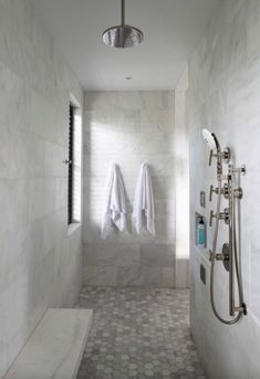 two white towels are hanging on the wall next to a window in a large bathroom