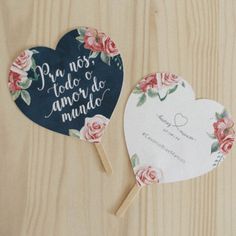 two heart shaped paper fans sitting on top of a wooden table