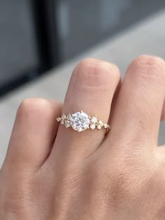 a woman's hand with a diamond ring on top of her finger and an engagement band