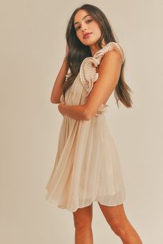 This sleeveless mini dress features a pleated design and a halter neck with a button closure. The open back is highlighted by delicate ruffle detail, and it is lined for comfort. 100% Polyester Sold online only Pleated Mini Dress, Sleeveless Mini Dress, Selling Online, Halter Neck, Open Back, Halter Dress, Mini Dress, Design