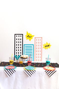 a table topped with plates and cups filled with desserts on top of a white table cloth