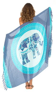 a woman is holding up a blue and white elephant towel