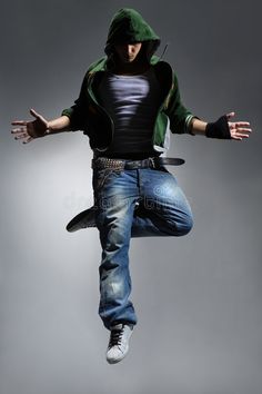 a man is jumping in the air with his hands out to catch something while wearing jeans and a hoodie