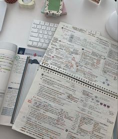 an open book sitting on top of a desk next to a keyboard