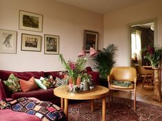 a living room filled with lots of furniture and plants on top of it's tables