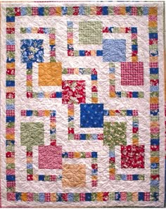 a colorful quilt is hanging on the wall