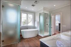 a large white bath tub sitting next to a walk in shower