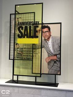 an advertisement is displayed on the wall in front of a man's suit and tie