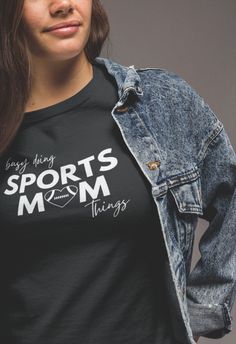 a woman wearing a t - shirt that says sports mom things on it and has her hands in her pockets