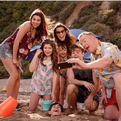 a group of people standing on top of a sandy beach