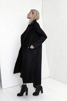 "Premium quality Black woolen coat has an oversize silhouette through the body , crafted in a heavy and thick high quality Italian wool fabric. Calf-length coat is fastened with two knobs. The coat has a unique cut , features big collar, long sleeves and is very stylish. This coat has a horizontal line through the front and back, there are large pockets in front. On one side on the shoulder is a decorative detail. The coat is with viscose lined. This coat is very stylish and unique created by a Black Sweater Coat With Pockets For Cold Weather, Oversized Long Wool Coat For Spring, Oversized Solid Pea Coat For Winter, Oversized Long Wool Coat, Oversized Winter Pea Coat For Cold Weather, Chic Black Solid Color Outerwear, Oversized Long Wool Coat For Work, Modern Black Pea Coat For Winter, Chic Black Wool Coat For Winter