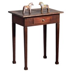 two wooden horses on top of a table with one drawer open and the other closed