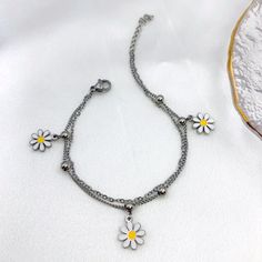 Embrace the girly charm of our Daisy Charms Bracelet and let it be your go-to accessory for every occasion. Whether worn alone or layered with other bracelets, it's sure to become a cherished favorite in your jewelry collection. Available in silver and gold. Trendy Stainless Steel Charm Bracelet, Trendy Adjustable Stainless Steel Charm Bracelet, Adjustable Flower Charms Bracelets, Adjustable Flower-shaped Bracelets With Charms, Everyday Bracelets With Dangling Charms, Adjustable Flower-shaped Charm Bracelets, Dainty Nickel Free Charm Bracelet For Friendship, Dainty Nickel-free Charm Bracelet For Friendship, Spring Metal Bracelets As Gift