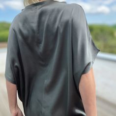 Elevate your wardrobe with our stunning lustrous grey satin top, designed in a loose-fit style. Fold the hem up over your hips or tucked into a pair of pants or a skirt. Whether it's a day at the office, a night out with friends, or a romantic date, this top adds an elegant touch to any occasion. Crafted from a luxurious heavyweight satin, it drapes beautifully, offering effortless sophistication with every movement Proudly made in Izmir Turkey by Kopenhag Studio Good to know The model is 5'6" and wears a small Ecovero from Lenzing is a sustainable vegan silk made from responsibly sourced wood pulp. Handwash inside out or wash inside out on cold Spring Sheen Tops For Workwear, Oversized Silk Tops For Summer, Sleek Viscose Top For Night Out, Chic Sheen Tops For Workwear, Casual Satin V-neck Top, Chic Oversized Tops For Evening, Sleek Silk Top For Night Out, Chic Spring Top With Sheen, Chic Sheen Top For Spring