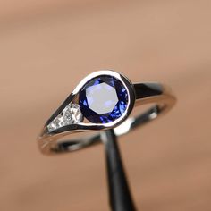 It is a lab sapphire ring. The main stone is 7mm*7mm round cut, weight about 1.63 carats. The basic metal is sterling silver and plated with rhodium. To change the metal to a solid gold (white/rose) or platinum is also available, please ask for a quotation if you want. You can also go to my shop Home for more elegant rings: https://www.etsy.com/shop/godjewelry?ref=hdr_shop_menu Sapphire is the birthstone of September. More sapphire rings: https://www.etsy.com/shop/godjewelry?ref=listing-shop2-al 2 Stone Rings Gemstones, Round Sapphire Engagement Ring, Octagon Ring, Elegant Rings, Sapphire Wedding Rings, September Birthstone Rings, Blue Gemstone Rings, Sapphire Rings, Round Cut Engagement Rings