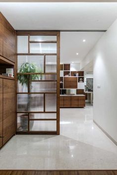 an open door leading to a kitchen with wooden cabinets and shelves on either side of the room