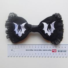 Spooky Bat Lover Ornaments, Funny Halloween Decor for Gothic Fashionistas, Fun and Spooky Decor for Bat Lovers, Gothic Barrettes, Gothic Bat ---------------------------------------------- Gothic bat hair clip made of black cotton canvas, black satin ribbon and black lace border. Bats are machine embroidered in white color. The back is sewn a metal barrette in silver color nickel free. Dimensions: width approximately : 18 cm (7"), height: 9 cm (3,5"), barrette length: 7,5 cm (3") Cute Halloween Hair Accessories For Party, Cute Halloween Party Hair Accessories, Black Fantasy Costume Accessories As Gift, Halloween Party White Hair Accessories, White Halloween Party Hair Accessories, Handmade Halloween Costume Accessories, Black Novelty Costume Accessories For Gift, White Gothic Costume Accessories, Dracula Hair