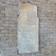 an old mirror hanging on the side of a brick wall