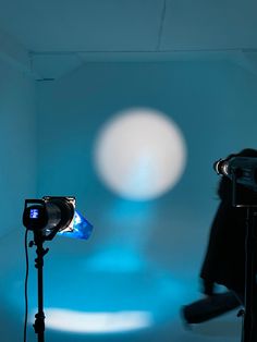 a person is standing in front of a camera and some lights on a blue background