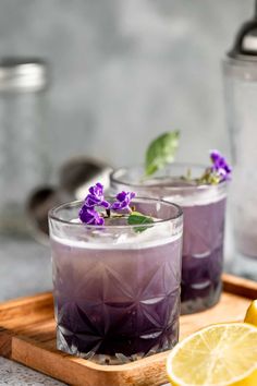 two glasses filled with lavender lemonade on a cutting board