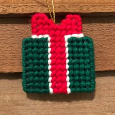 a crocheted christmas ornament hanging on a wooden door frame with a chain