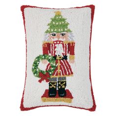 a christmas pillow with a santa clause holding a wreath