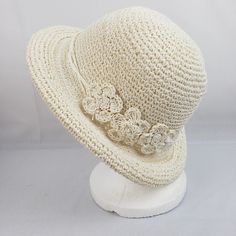 a white crocheted hat with flowers on it's brimmings