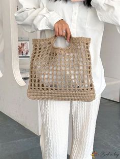 a woman wearing white pants and holding a beige bag with crochet on it