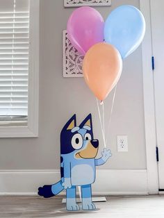 a paper cutout of a dog holding balloons