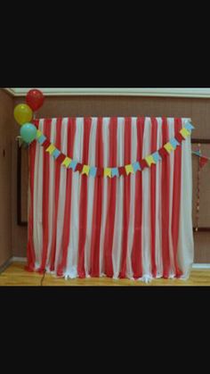 a red and white striped curtain with balloons