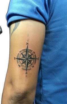 a man with a compass tattoo on his arm