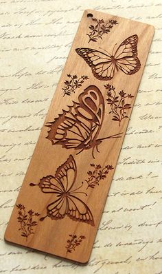 a wooden bookmark with two butterflies on it