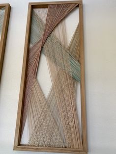 two framed art pieces on the wall next to each other, one is made out of sticks